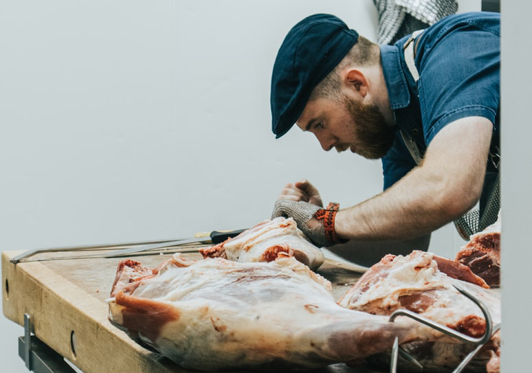 a butcher skilfully cutting meat